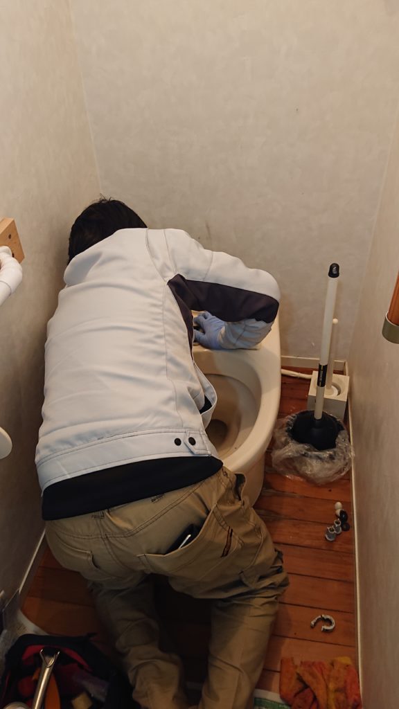 トイレを修理している男性